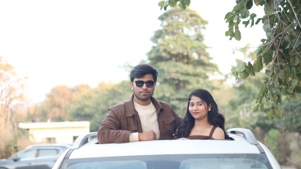 Romantic outdoor pre wedding shoot of a couple posing through a car sunroof with natural greenery background in Jodhpur